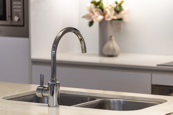 Stainless steel kitchen faucet over modern sink