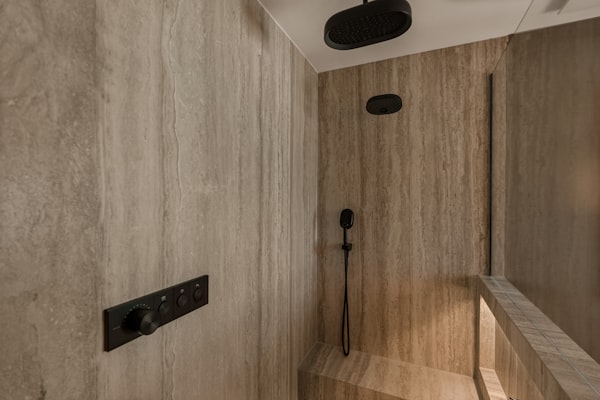 Modern walk-in shower with rain shower head and stone tiles